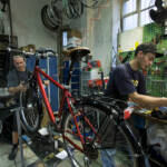 Deux hommes travailant dans un atelier de réparation de vélos Deux hommes travailant dans un atelier de réparation de vélos